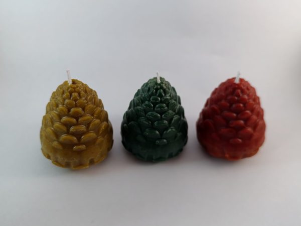 Velas artesanales en forma de piña hechas con cera de abeja natural en colores rojo, verde y amarillo