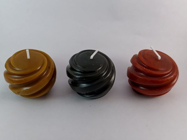 Velas artesanales en forma espiral hechas con cera de abeja natural en colores rojo, verde y amarillo